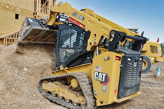 255 skid steer lifting up dirt on job site