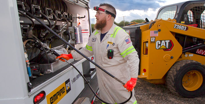 lube technician on site with skid steer