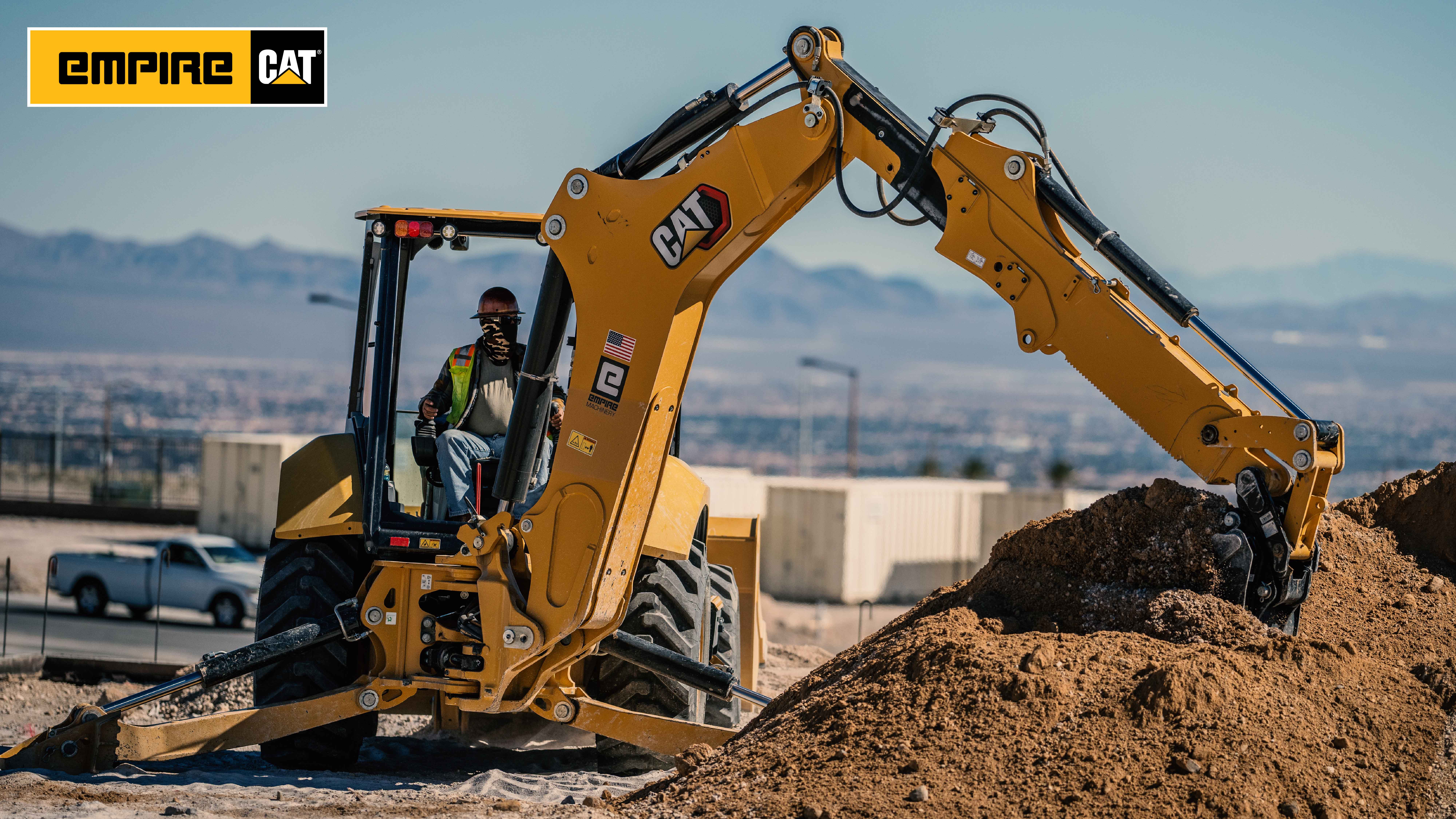 backhoe loader digging into a pile of dirt